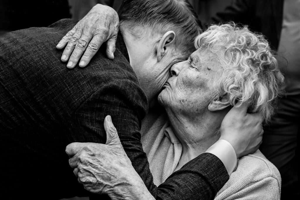 Omhelzing van oma op een bruiloft gefotografeerd