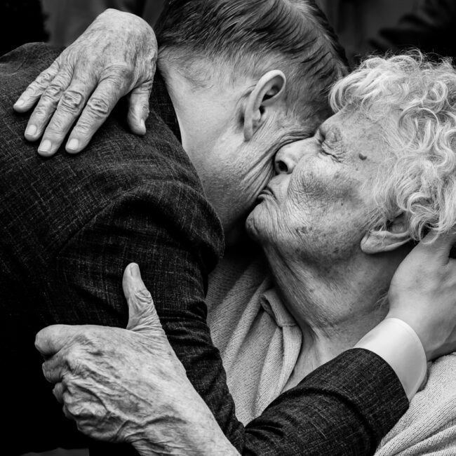 Omhelzing van oma op een bruiloft gefotografeerd