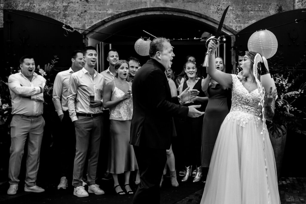 Bruidspaar die champagne sabreert op trouwdag